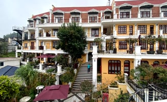 a building with a staircase leading to a building with a red roof