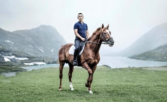 A rider on a horse in a mountain setting, embodying elegance and adventure for an equestrian brand.