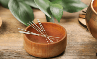 Aiguilles d'acupuncture dans un bol en bois, bol tibétain à coté