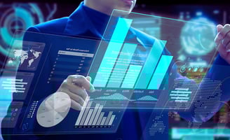 Business leader in a blue suit reviews holographic graphs and charts on transparent glass screens, face unseen.