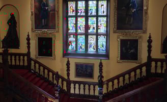 Staircases in a mansion with paintings and artifacts