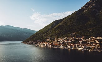 a boat is sailing in the water near a mountain