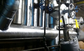 Licensed lead abatement team conducting lead pipe removal and testing in commercial building