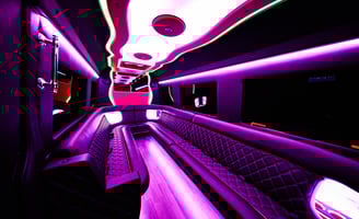 The inside of a party bus limo with pink neon