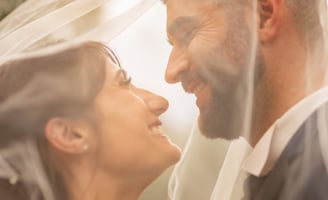 a bride and groom are standing in front of a veil