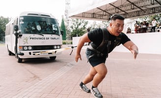 a man pulling a bus in a strongman competition
