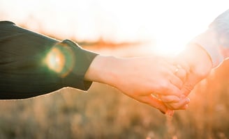 Close up of man and woman holding hands. 