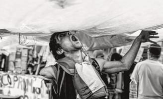 a man with a large umbrella in a tent