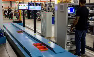 a man standing in a factory with a large screen tv