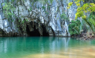 Entrada do rio subterrâneo de Puerto Princesa, com formações rochosas ao redor.