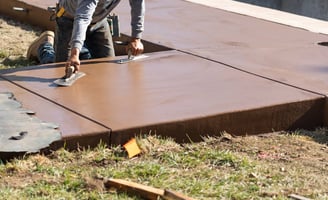 a man is using a knife to cut a concrete slab