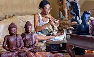 a man sitting on a couch with a wooden statue