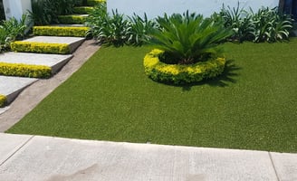 Pasto sintético verde instalado en un jardín residencial en Guadalajara