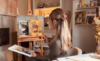 a woman is sitting in a chair and painting