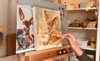 a woman is painting a picture of a dog