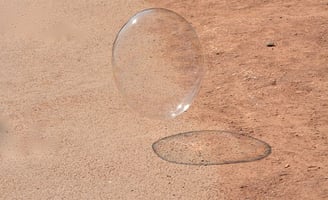 Schwebende Seifenblase auf feinem Wüstensand unter der Sonne