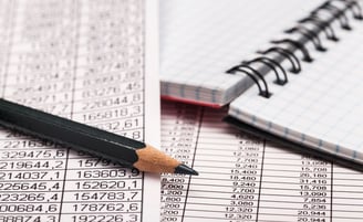 a pencil on a notebook and financial data