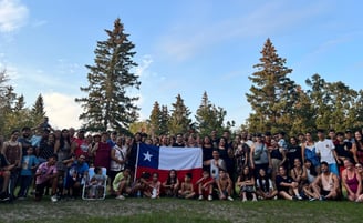 a group of people standing in front of a Chilean flag
