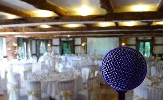 a microphone in a wedding breakfast room with tables and chairs