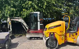 mini digger and roller in a commercial yard