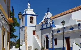 Alvor’s Igreja do Divino Salvador, a white and blue church with traditional Portuguese architecture