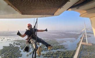 a man is hanging from a helicopter while he is hanging from a rope