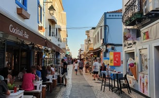 Charming cobbled street in Alvor lined with lively bars, shops, and colorful storefronts.