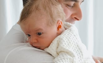 a man holding a baby in his arms