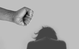 A mão de um homem ameaçando mulher remetendo a lei maria da penha contra a violência doméstica
