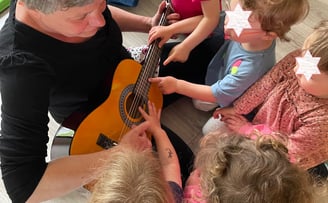 éveil musical, jeunes enfants découvrent le son d'un instrument