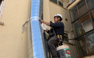 Trabajador arreglando tubería de ventilación