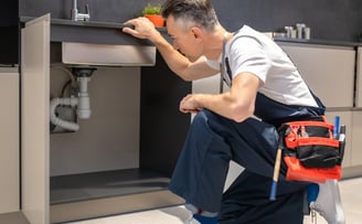 <a href="https://www.freepik.com/free-photo/man-kneeling-down-touching-sink-inspecting-pipes_2226482