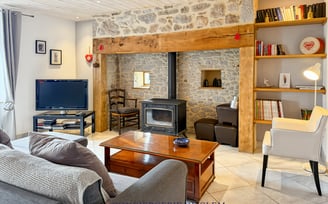 grand séjour, canapé, fauteuil, cheminée dans le cantal