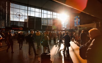 a group of people walking through a busy train station