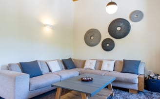 Modern and minimal country house living room with wood stove and corner sofa
