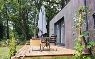 Cabane en bois naturel nichée dans un écrin de verdure
