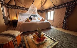 a bed with a canopy tented bed and a table with fruit on it