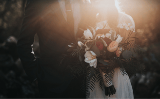 a bride and groom holding a bouquet of flowers