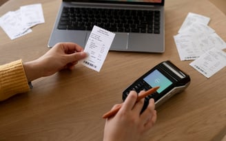 A person using a smartphone to pay bills, with a focus on the bill payment app or website for VA