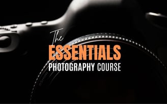 Close-up of a camera lens with text “The Essentials Photography Course” overlayed.