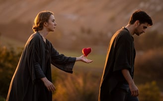 a man and woman holding a red heart shaped object