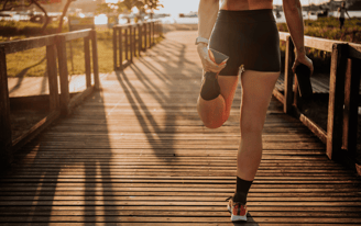 a woman in a sports bra top and shorts is running