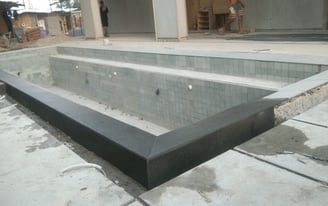 kolam renang struktur beton dengan finishing batu hijau