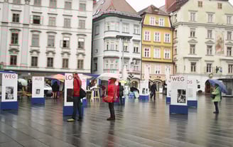 Menschen gehen durch die Ausstellung "Aus weg los!" auf der Grazer Hauptplatz.