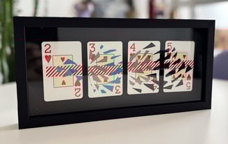 imagem da obra, composta por 4 cartas de baralho com intervenções de washi tape e fita isolante, emolduradas com fundo preto.