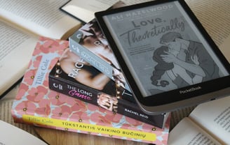 a pile of books with a kindle on top