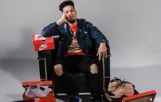 a man sitting in a chair with a shoebox and a shoebox of sneakers