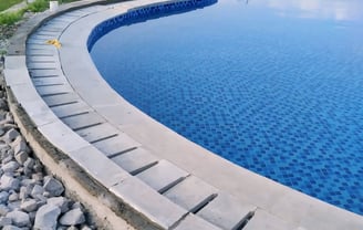 Kolam renang berbentuk lingkaran dan keramik berwarna biru.