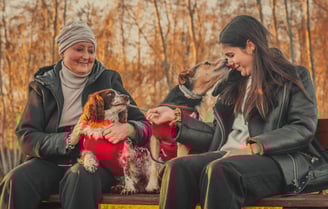 signora su panchina con figlia e cani