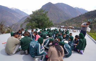 People sitting on the ground amidst mountains